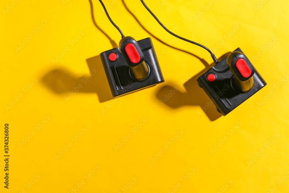 Poster old joysticks on yellow background with shadow. retro gaming. top view