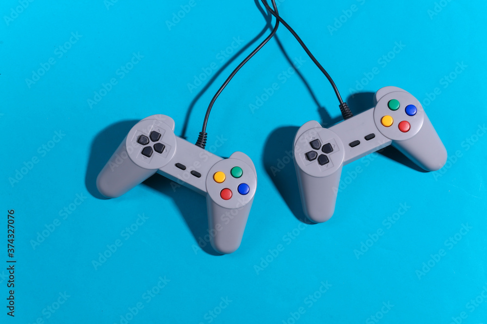 Poster retro gamepads on blue background with shadow. retro gaming. top view