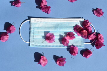Mask face with flowers on blue background