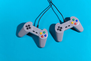 Retro gamepads on blue background with shadow. Retro gaming. Top view © splitov27