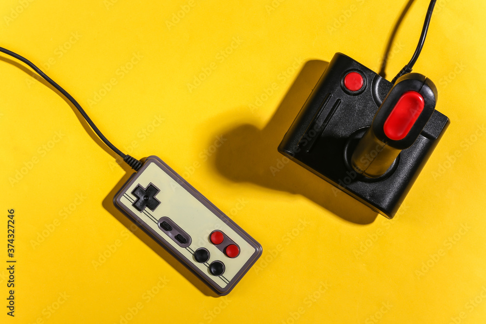 Poster retro joystick and gamepad on yellow background with shadow. retro gaming. top view