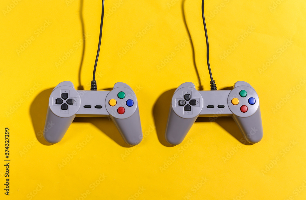 Poster retro gamepads on yellow background with shadow. retro gaming. top view