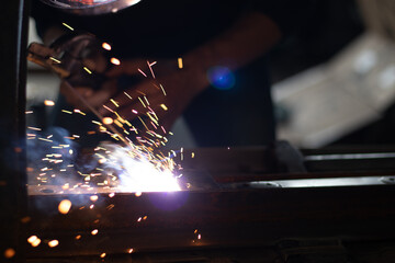Obraz premium Worker,welding in a car factory with sparks, manufacturing, industry