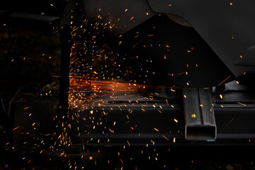 orange sparking fire from metal cutting with machine industrial activity black background