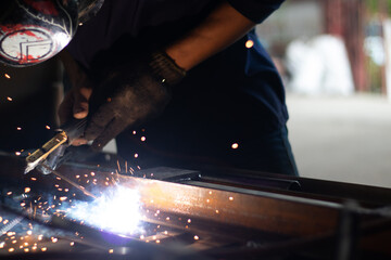 Worker,welding in a car factory with sparks, manufacturing, industry
