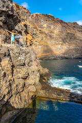 A young tourist in summer from the viewpoint looking and enjoying the cove of Puerto de Puntagorda,...