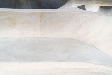 Fototapeta na wymiar Concrete public skate park on a sunny day. Cement ramps for skateboarding and bmx. Extreme sport