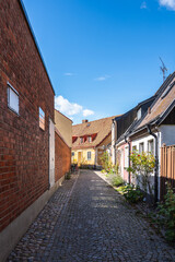 Fototapeta na wymiar An empty cozy cobblestoned street with town houses and cottages in the village of Ystad, Sweden