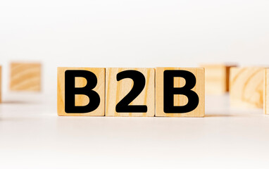 A wooden block with the word B2B Business to business written on it on a white background