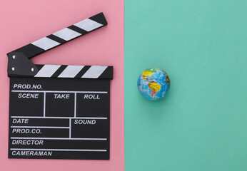 Movie clapper board and globe on pink blue background. Filmmaking, Movie production, Entertainment...