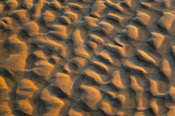 Abstract view of natural sand dune formation at the beach. Curly sand wave pattern closeup. Beautiful sandy background. Nobody