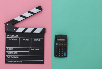 Movie clapper board and calculator on pink blue background. Cinema fees. Filmmaking, Movie...