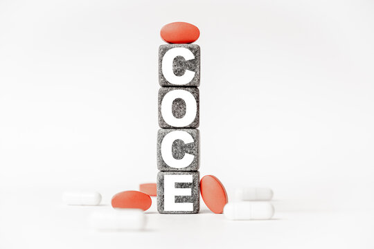 a group of white and red pills and cubes with the word coce on them, white background. Concept carehealth, treatment, therapy.