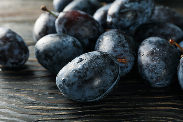Fresh plums on wooden background, close up