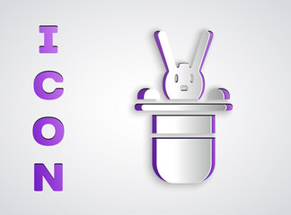 Paper cut Magician hat and rabbit icon isolated on grey background. Magic trick. Mystery entertainment concept. Paper art style. Vector.