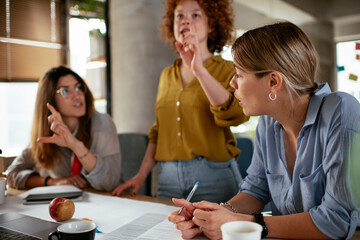 Businesswomen working on a new project. Colleagues discussing about problem they have to solved..