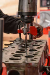 A craftsman sets up a machine for grinding car valves