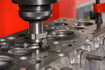 A machine for grinding car valves is being set up in the workshop.