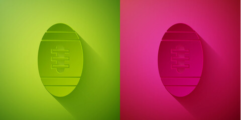 Paper cut American Football ball icon isolated on green and pink background. Rugby ball icon. Team sport game symbol. Paper art style. Vector.