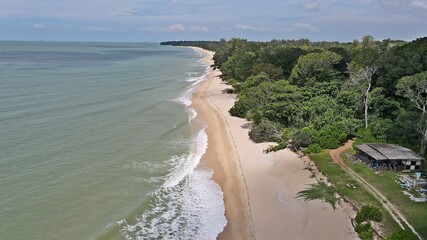 Desaru Beach with the lovely white sandy beach, turquoise sea, ocean waves, blue sky and stormy...