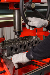 A craftsman sets up a machine for grinding car valves