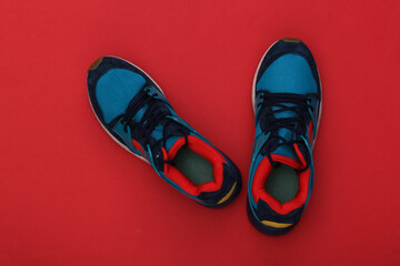 Running shoes (sneakers) on red background. Healthy lifestyle. Top view