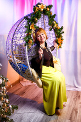 Fat beautiful girl in a room decorated for Christmas and New year. Middle aged woman and model posing in nice studio.