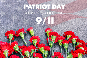 Carnations on the memorial with the American flag and the phrase patriots ' Day. September 11. We will never forget. Anniversary of the attack.