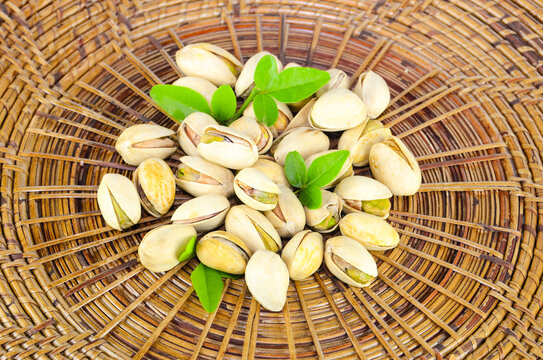 Many nuts are placed on a handmade bamboo craft container made of brown bamboo.