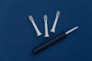 Electro toothbrush with replaceable heads on classic blue background. Color 2020. Top view
