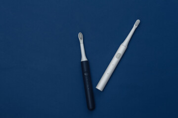 Electro toothbrushes on classic blue background. Color 2020. Top view