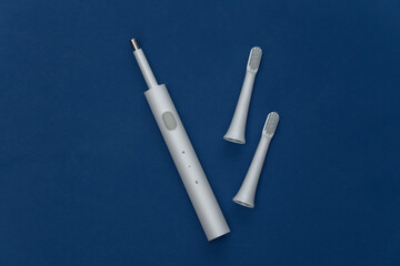 Electro toothbrush with replaceable heads on classic blue background. Color 2020. Top view