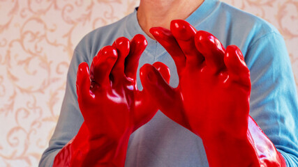 Man in red rubber protective gloves, protecting skin from chemicals