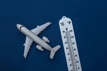 Weather thermometer with  toy plane on classic blue background. Color 2020. Tiop view