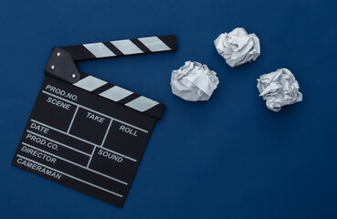 Movie clapper board with crumpled paper balls on classic blue background. Filmmaking, Movie...