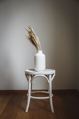 Seaside bents in a white vase on a white stool