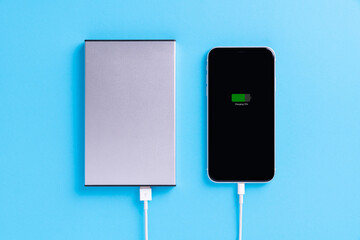 phone charging with external power supply on blue background - 374338660