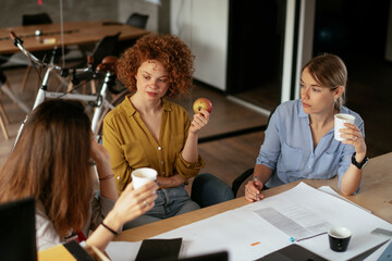 Businesswomen working on a new project. Colleagues discussing about problem they have to solved..