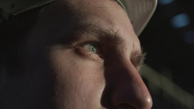 An engineer, builder, manager puts a white helmet on his head at sunset and looks into the distance. Inspired, focused gaze, blue eyes, innovative, new architectural, building project of the future.