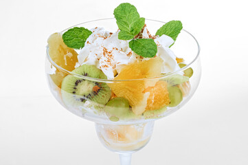 Raw vegetarian fruit dessert with kiwi, pineapple, green grapes and whipped cream