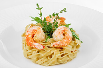 Pasta with grilled shrimps, cream sauce and herbs on top
