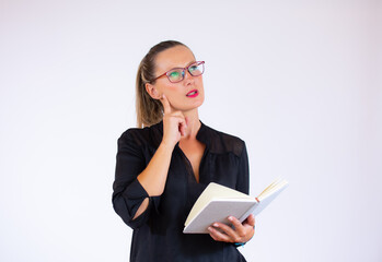 Pretty businesswoman with a notebook with doubtful gesture