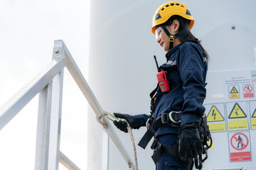 Asian woman Inspection engineer wearing safety harness and safety line working preparing and...