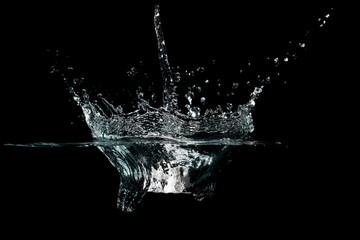 close up of water waves splash and bubbles isolated on black background.