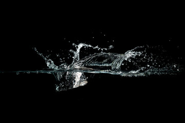 close up of water waves splash and bubbles isolated on black background.