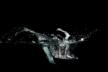 close up of water waves splash and bubbles isolated on black background.