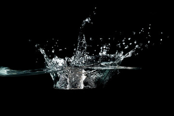 close up of water waves splash and bubbles isolated on black background.