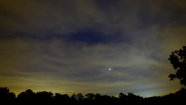 Time lapse of moon rising behind moving cloudscape