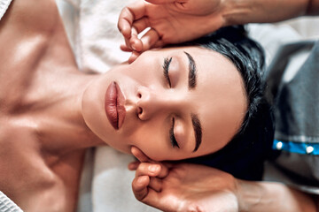 Close-up view portrait of young beautiful woman in spa environment.