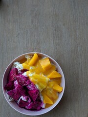 Bowl of bingo (Korean shaved ice dessert) with mango and dragonfruit on top.